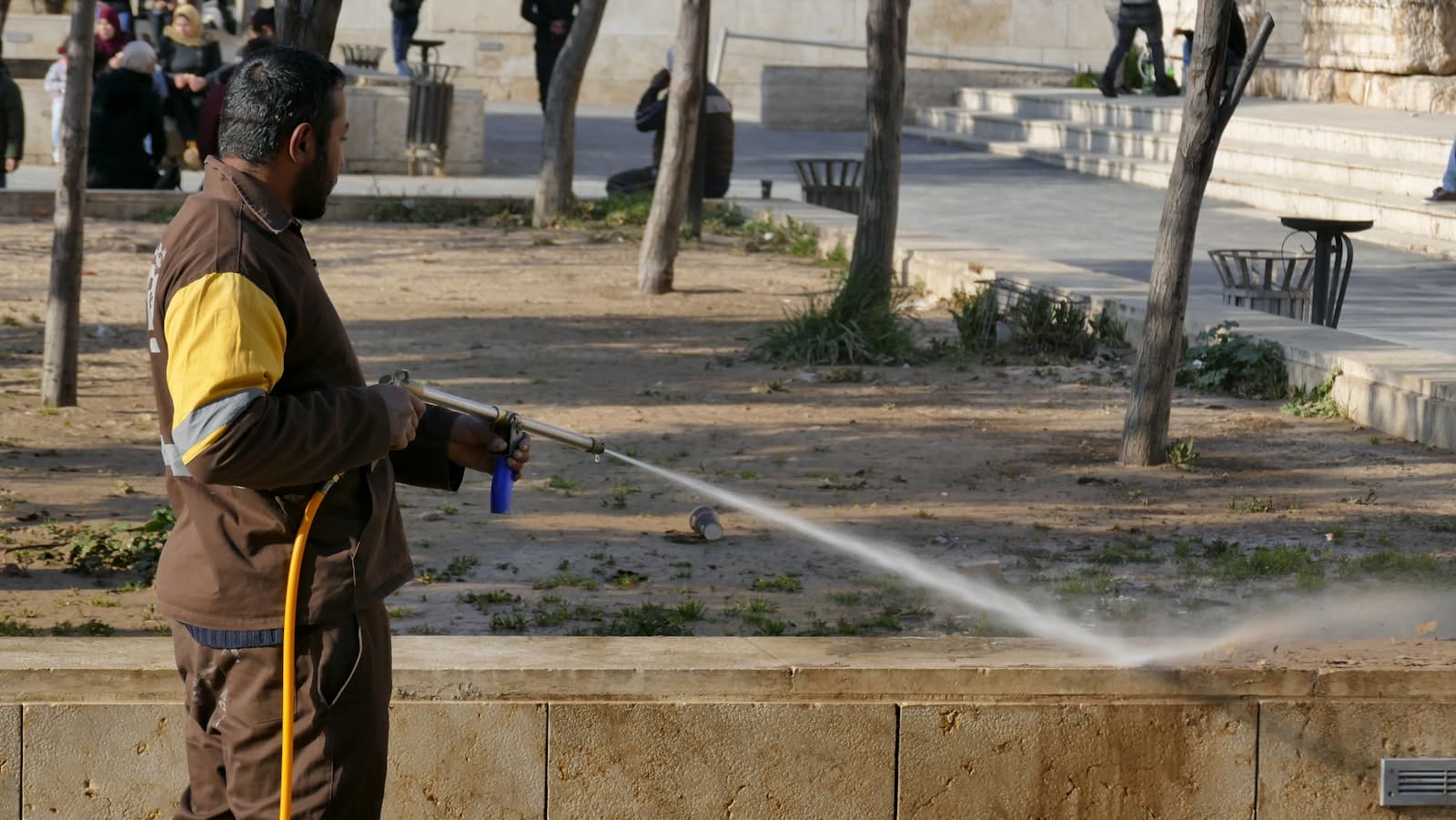 Technician pressure washing a stone surface clean